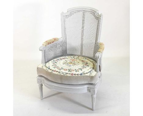 A Louis XVI and later cream painted bergere armchair, with a cane back and tapestry cushion, on fluted legs65w x 59d x 93h cm