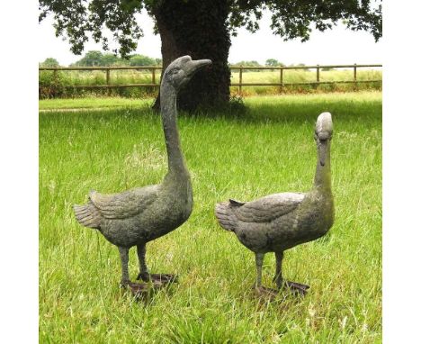 A weathered metal garden model of a goose, 68cm high, together with another smaller (2)