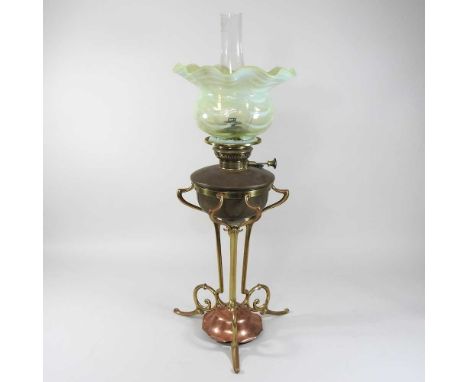 An Arts and Crafts copper and brass oil lamp, in the manner of W A S Benson, circa 1900, with a frilled green vaseline glass 