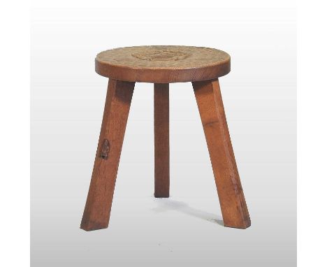 A mid 20th century light oak footstool by Thomas 'Gnomeman' Whittaker of Yorkshire, the circular adzed top carved with a cent