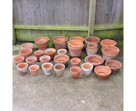 A large collection of terracotta garden pots, largest 28 cm high