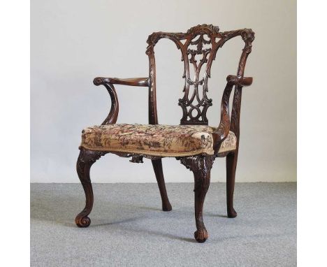 A George III style carved mahogany elbow chair, of Chippendale design, early 20th century, of large proportions, with a tapes