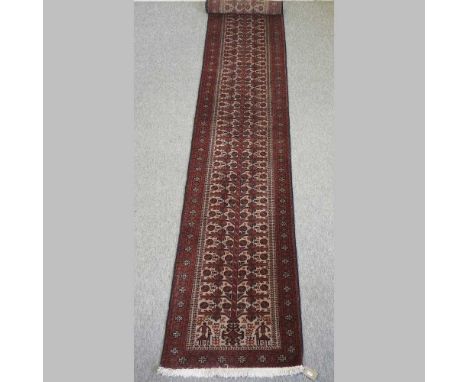 An Afghan woollen runner, with three rows of medallions, on a red ground386 x 61cmCondition report: Looks quite modern and ha