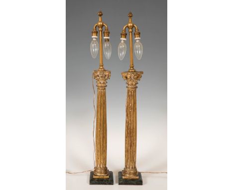 Pair of lamps, after 17th century models; early 20th century.Gilded wood, brass and marble base.Slight damage to the carving.