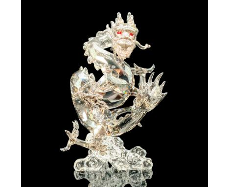 A dark toned crystal dragon sitting atop a base of clear crystal swirls with red crystal used for the eyes. Swarovski backsta