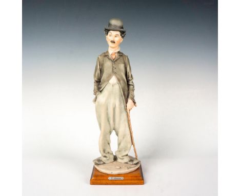 This figurine features the renowned Charlie Chaplin standing on a square wooden base. Figurine 3219. Giuseppe Armani golden p