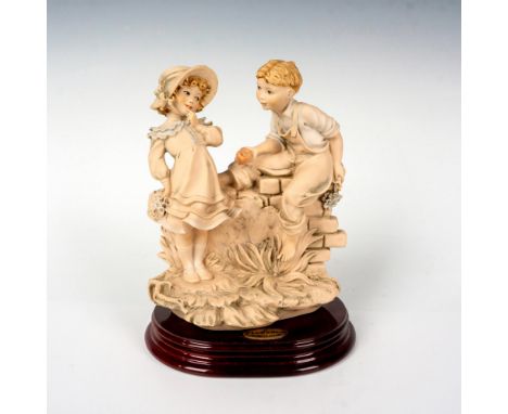 Features a youthful couple in a flirtatious stare exchanging an apple and flowers. This scene is set on a square wooden base.