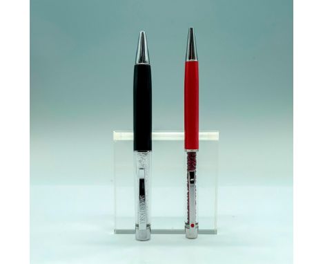 A pair of Swarovski pens, one black with clear crystals in the interior and Swarovski written on the pen clip. The other is a