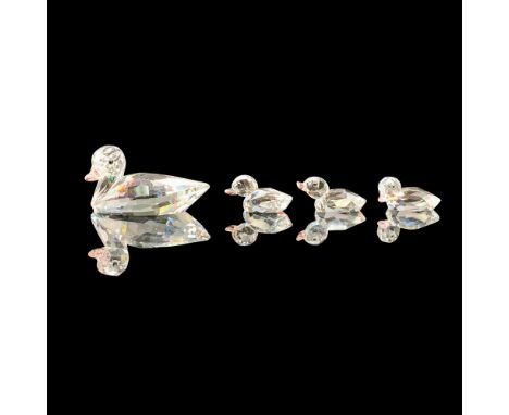 A set of four crystal figurines that includes a mother duck and her three ducklings. The figures are all clear with pink crys