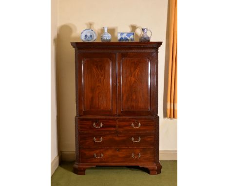 A George III mahogany clothes press, circa 1770, the moulded cornice with Greek key and blind fretwork, above a pair of panel