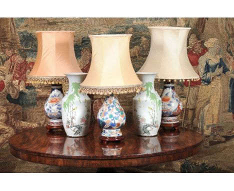 A pair of Chinese Imari style porcelain pear shaped vases, modern, later fitted for electricity as lamps, with carved wood st