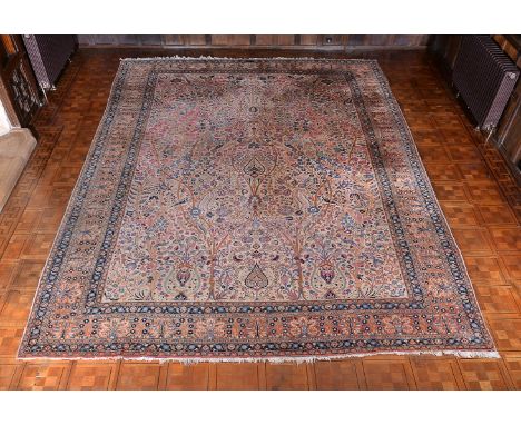 A Tabriz carpet, the cream field decorated with flowering vines in tones of pink, blue and ochre, within a similarly decorate