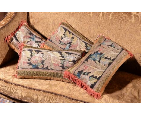 A set of four cushions incorporating 18th century tapestry fragments, the tapestry depicting leafy foliage, various sizes; to