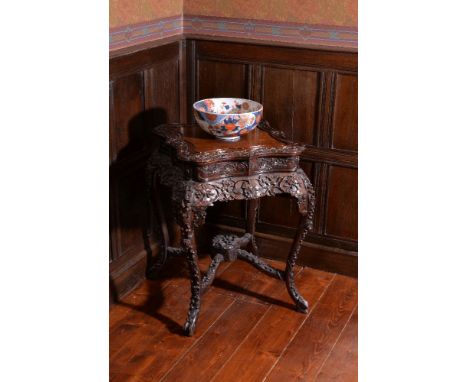 A Chinese carved hardwood occasional table or stand, 19th century, decorated throughout with floral and foliate motifs, the s
