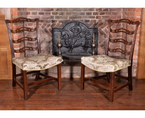 A pair of George III mahogany chairs, circa 1780, each shaped and pierced ‘ladder’ back above a tapering rectangular padded a