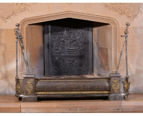 A Regency gilt brass mounted steel fender and tool set, circa 1815, the frieze pierced with foliate and acorn motif and with 