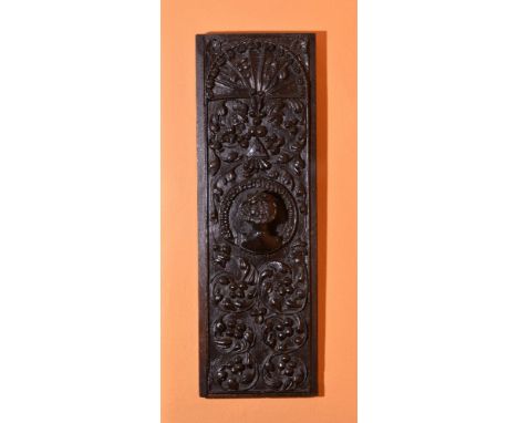 A carved oak panel, late 16th/early 17th century, carved with fruiting vines and centred by a portrait roundel, depicting the