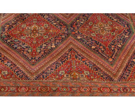 A Joshaghan carpet, the polychrome field decorated with lozenge motifs within multiple boarders decorated with stylised folia