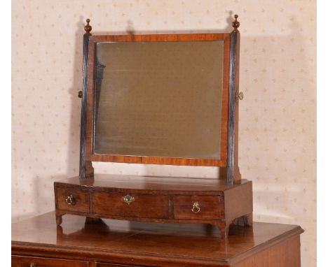 A George III mahogany dressing mirror, circa 1800, the rectangular swing plate supported by reeded uprights, surmounted by tu