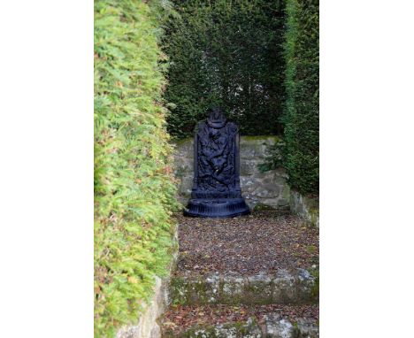 A black painted cast iron wall fountain, early 20th century, with cabochon cresting above a relief cast backplate with a rive