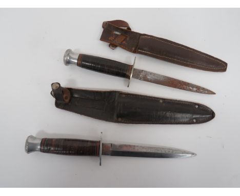 Two Commercial Combat Knivesconsisting 6 inch, double edged blade.  Alloy, oval crossguard and ball pommel.  Leather washer g