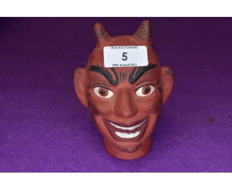 A ceramic puppet or similar toy head in the form of a Devil