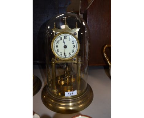 A vintage brass anniversary clock having glass dome and enamel face.