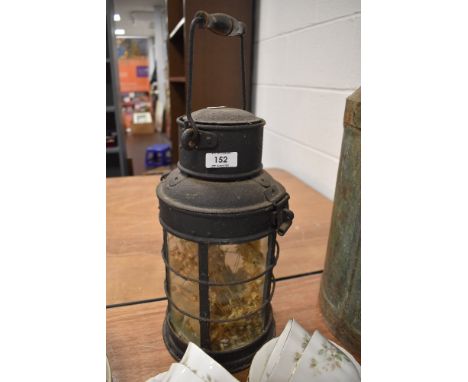 A vintage lantern having glass faces to sides and pivoting handle.
