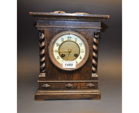 An oak cased mantel clock, c1900, barleytwist columns, Arabic numerals, key and pendulum