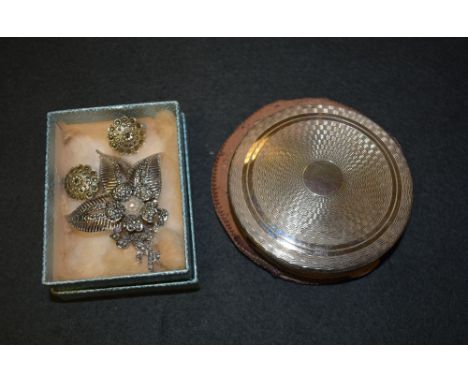 A silver circular engine turned powder compact, by Kiug, London 1949; a sterling silver leaf shaped brooch, the floral centre