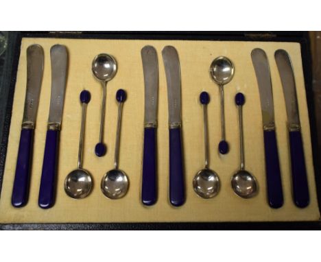An Art Deco style butter knife and coffee spoon set, royal blue handles, original velvet/silk lined box 