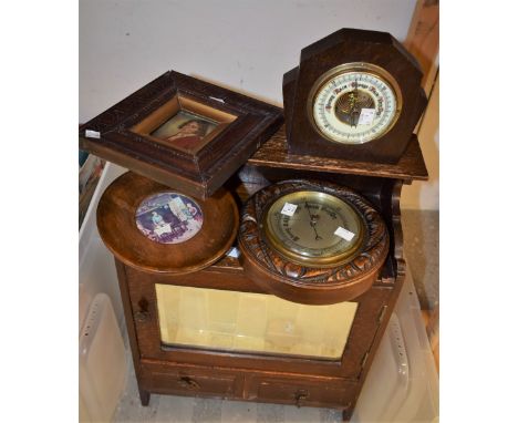 A circular aneroid barometer, carved oak case, c1900; another oak cased Art Deco style barometer; an oak wall hanging cupboar