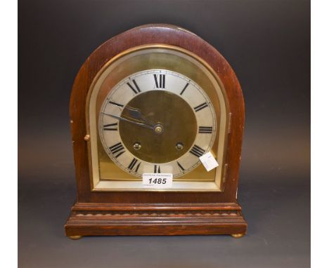 A mahogany cased arch mantel clock, brass and silver dial, Roman numerals, key and pendulum