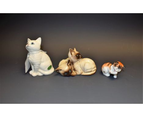 A Beswick group, of Siamese cats, printed marks; another, single cat; a Royal Doulton model, of a cat, printed marks 