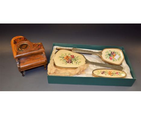 A musical walnut trinket box; an embroidered four piece brush set