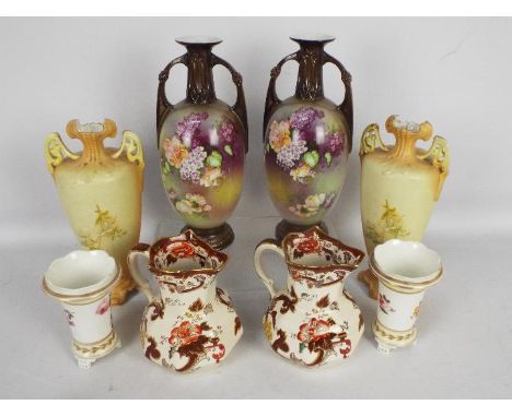 A pair of twin handled vases with floral decoration, a pair of tapered vases with floral decoration, raised on tripod support