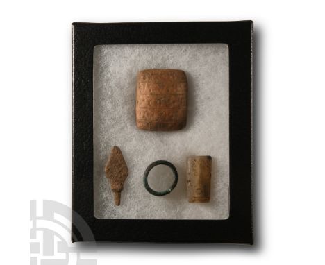 20th century A.D. Comprising: a reproduction terracotta pillow-shaped tablet with cuneiform inscription; arrowhead; tri-facia