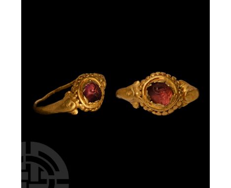 14th-16th century A.D. or earlier. Slender hoop with dolphin-shaped shoulders supporting a round bezel with pelletted perimet