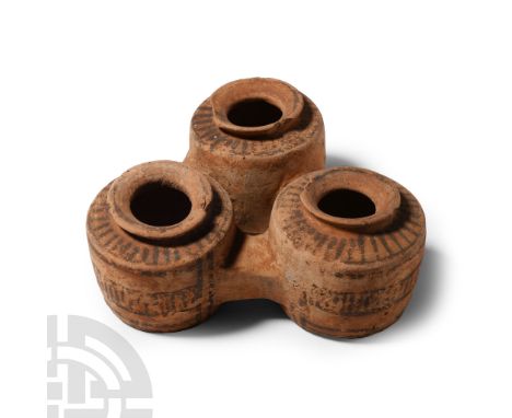 1st millennium B.C. Three drum-shaped ceramic vessels each with a flared rim and flat underside, connected by spurs at the eq