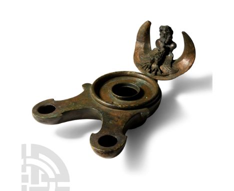 3rd-4th century A.D. With a rounded body and double nozzle with volutes; the body flat with engraved volutes, raised rim and 