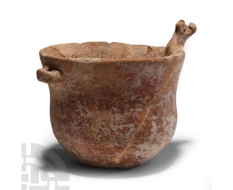 Bronze Age, circa 2000 B.C. Bell-shaped jar with pierced lug below the rim, applied bull-head opposite; repaired.  670 grams,