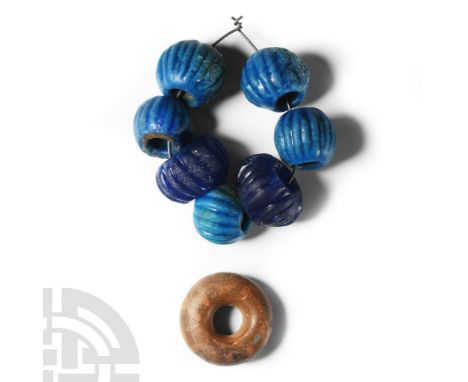 Circa 1st century A.D. Comprising seven blue glass melon beads and a ring-shaped bead with painted detailing.  66 grams total
