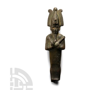 Late Period, 664-525 B.C. Modelled in the round wearing the atef crown with a uraeus to the brow, arms crossed on the chest h