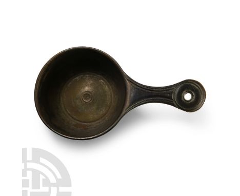 1st-2nd century A.D. With drum-shaped bowl and thick rim developing to a short handle with pierced lobe finial; stamped to th