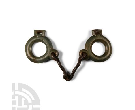 2nd-3rd century A.D. Comprising a pair of curved iron bars linked at the centre, loop at each outer end attached to a substan