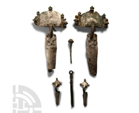 5th century A.D. Comprising: matched pair of silver bow brooches, each a D-shaped headplate with lateral posts and knop finia