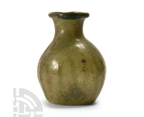 4th-6th century A.D. Bulbous in profile with dimpled underside, blown construction, everted rolled rim. Cf. Whitehouse, D., R