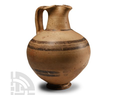 Iron Age, circa 700-475 B.C. With trefoil folded rim to the mouth, painted bands to the strap handle, shoulder and lower body