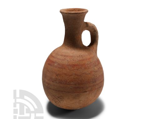 1900-1600 B.C. Of bulbous profile with loop handle and trumpet-shaped mouth, circumferential bands of red pigment. Cf. Morris