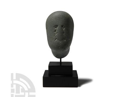 Circa 2nd century B.C.-1st century A.D. Carved stone male head with almond-shaped eyes, snub nose, prominent moustache; surfa